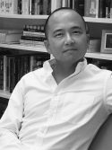 Portrait Jongwoo Jeremy Kim sitting in front of a bookshelf
