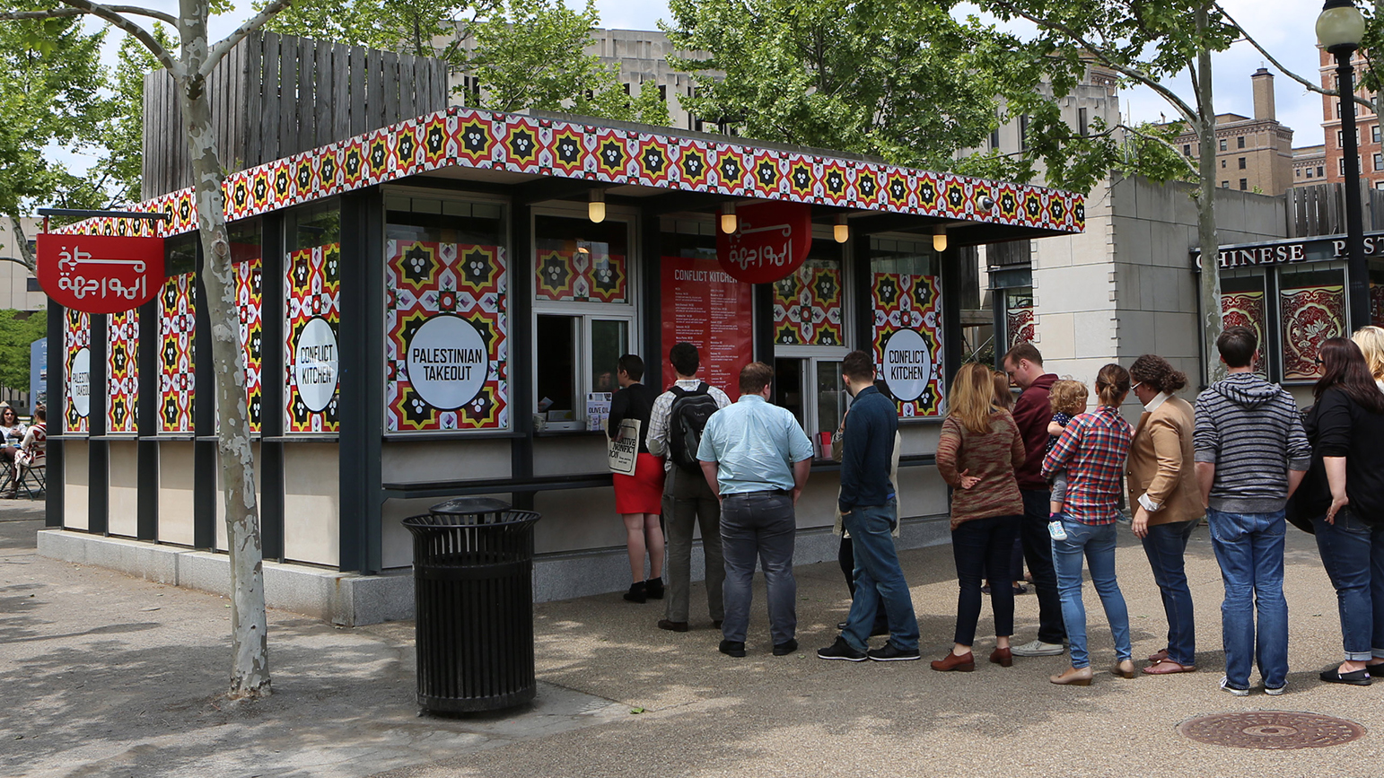 Photograph showing the exterior of the Palestinian version of Conflict Kitchen with a line of people