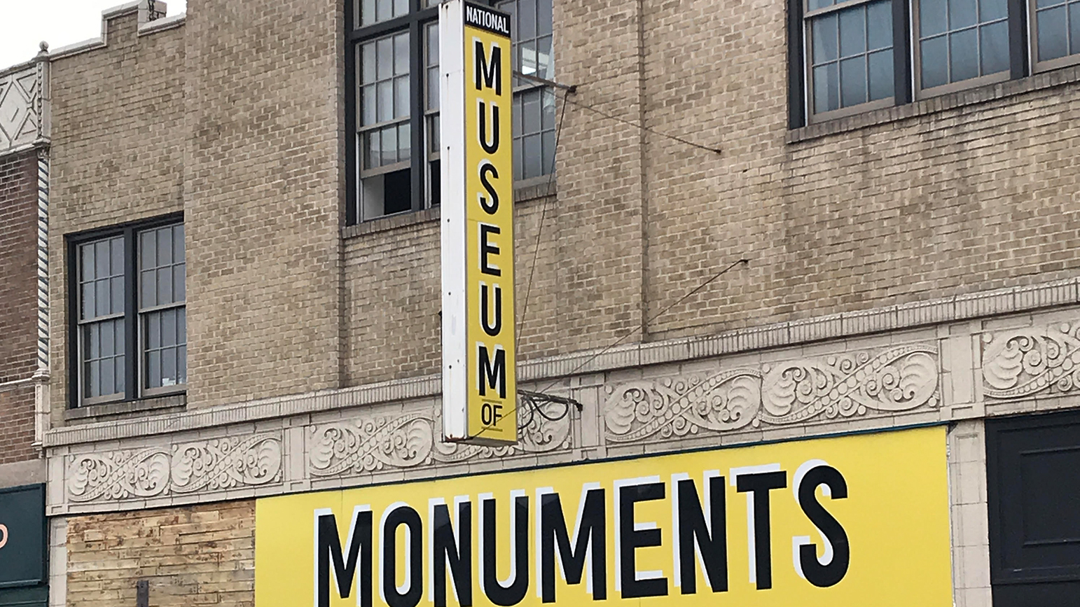 Photograph of a store front with signage reading "National Museum of" and "Monuments"