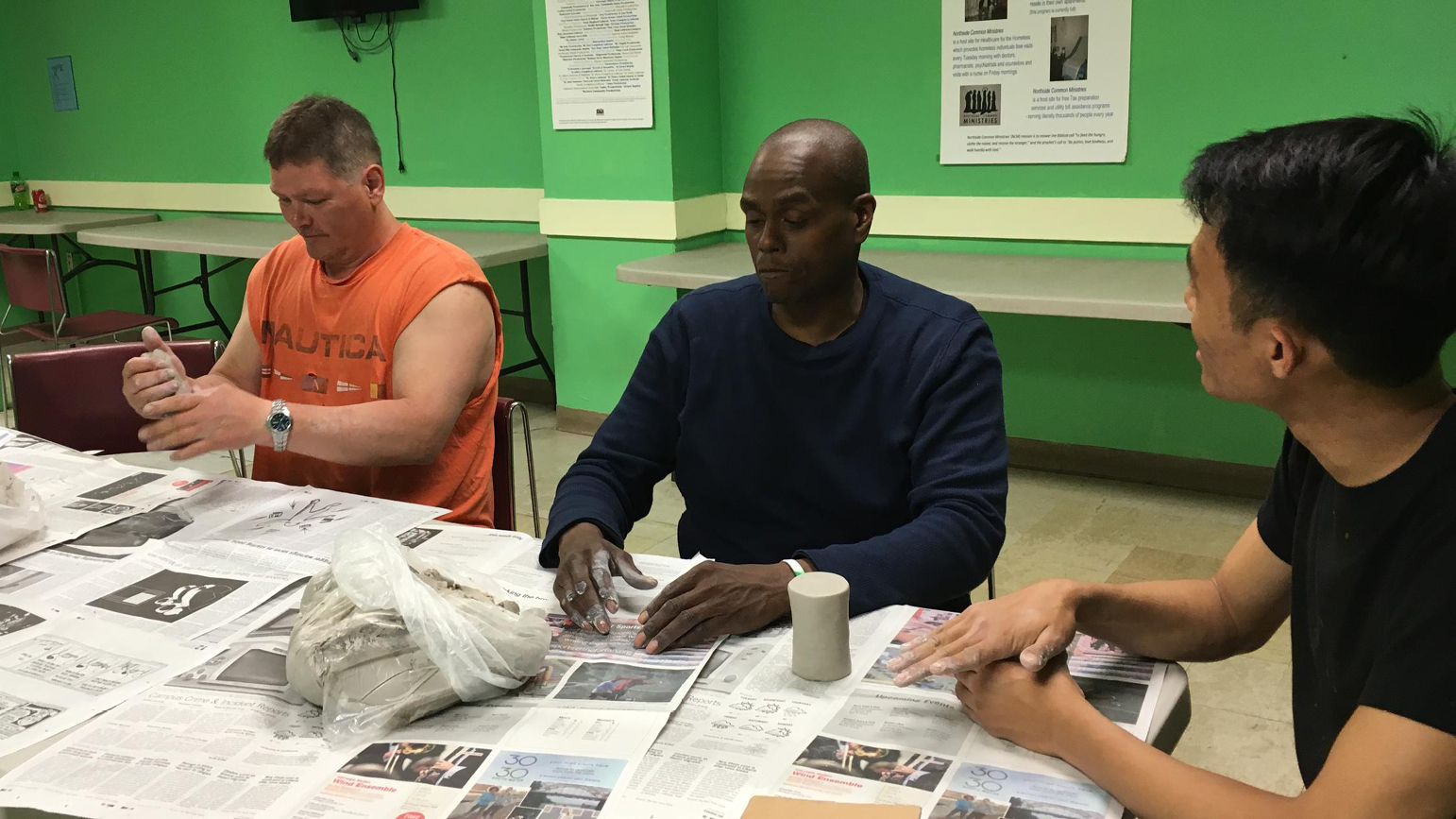 Photograph of three people making ceramic cups