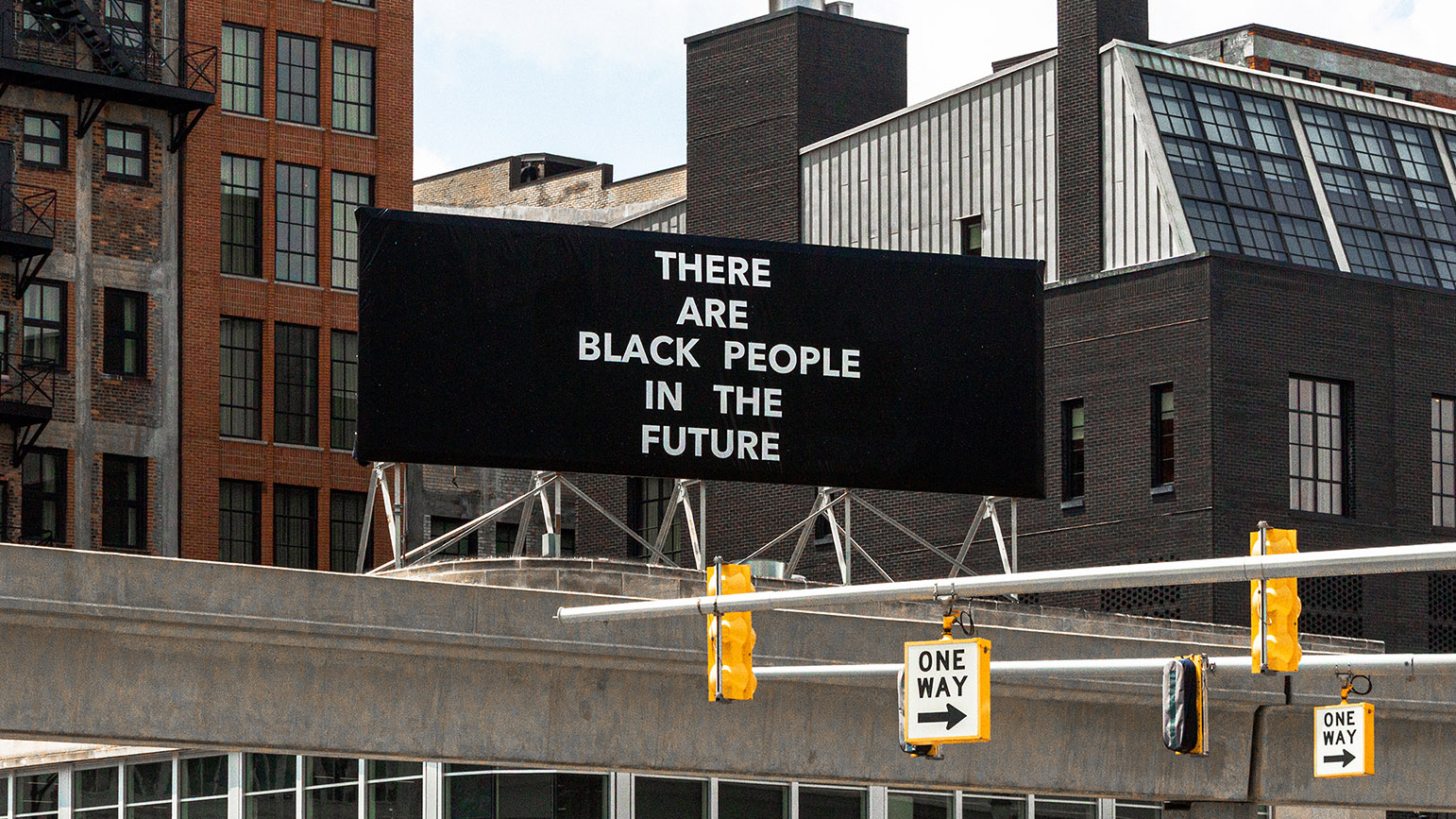 Photograph of a black billboard with the words "There Are Black People in the Future" written in white capital letters