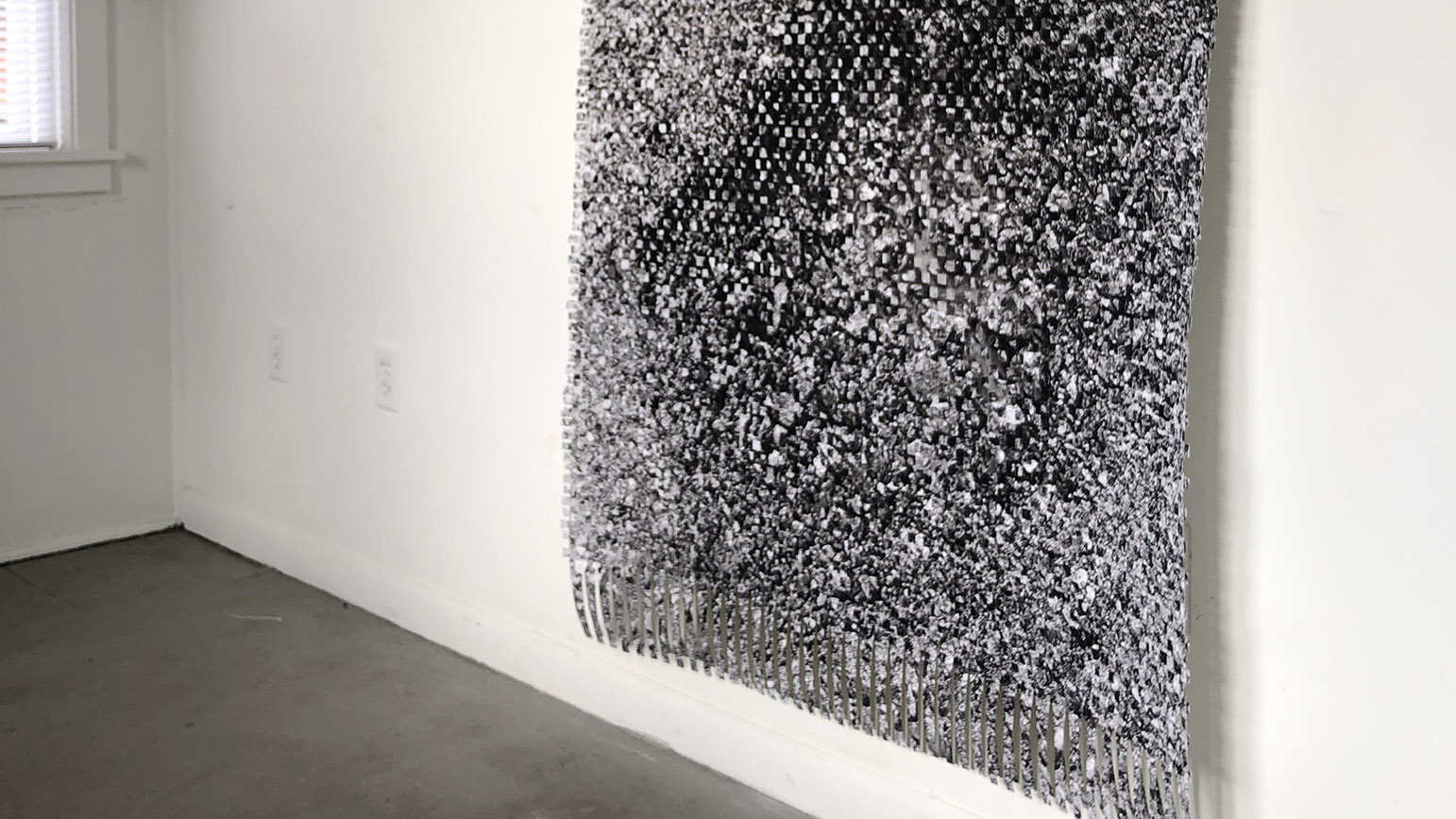Photograph of a paper weaving of road texture installed in a gallery