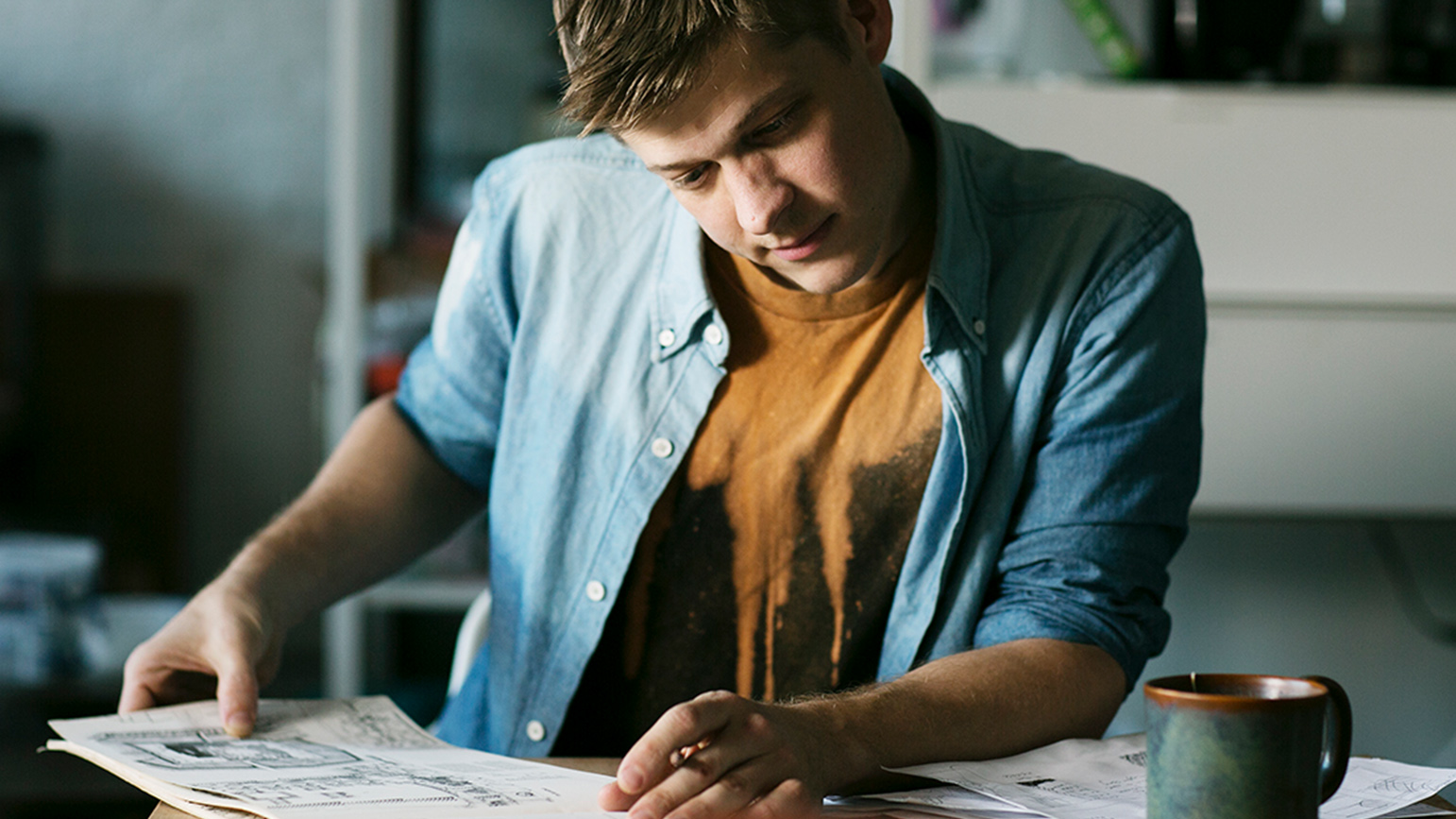 Photograph of Peter Burr sitting at a table working with a pencil in his hand