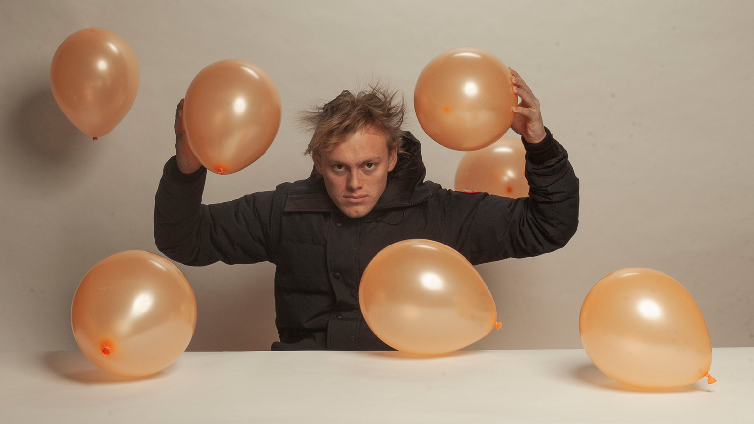 Photograph of Jackson Bridgers surrounded by balloons