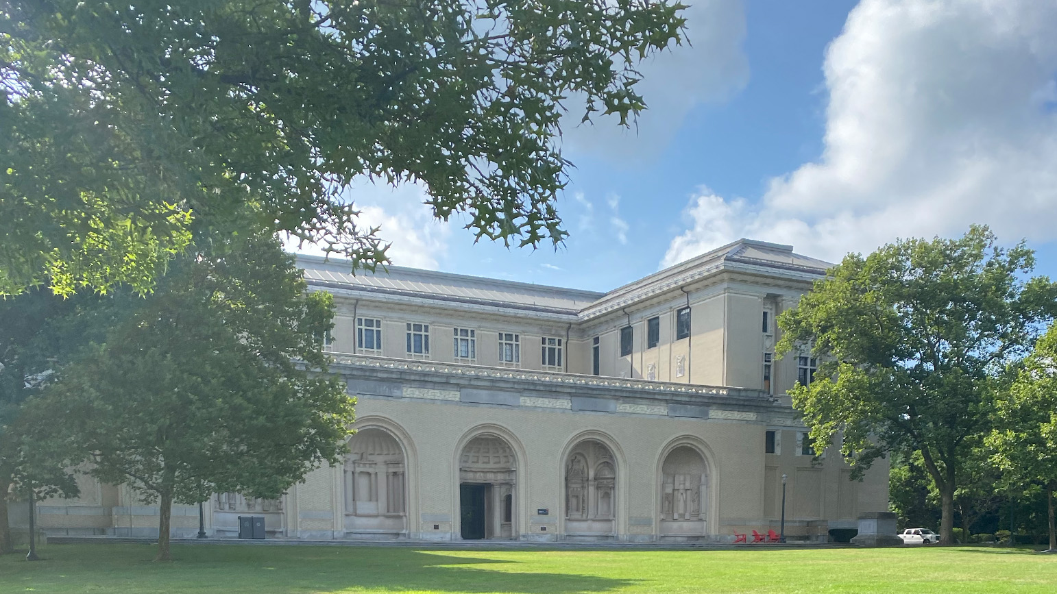 Photograph of the exterior of CMU's College of Fine Arts, a beaux-arts building with large trees in front