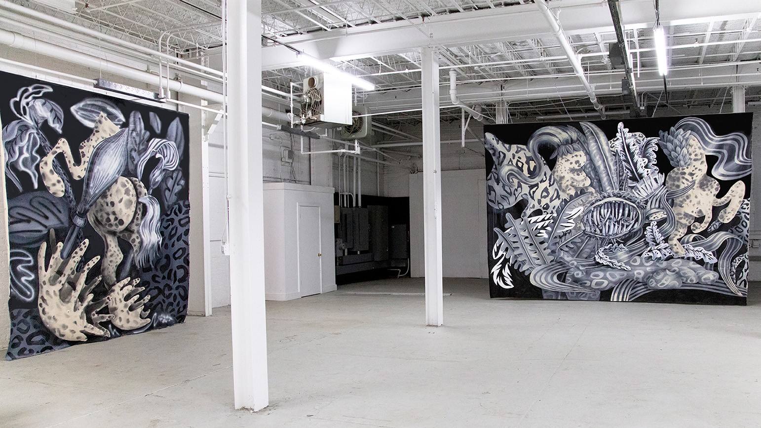 Two large abstract paintings in grisaille installed in a warehouse
