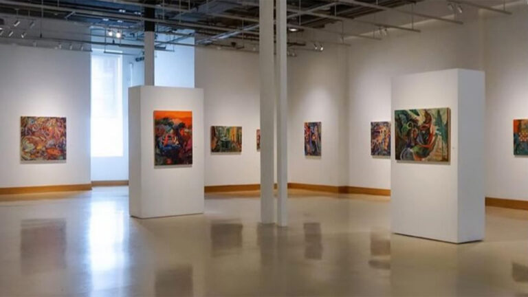 Image of a white-wall art gallery with a series of eight abstract and colorful paintings installed.